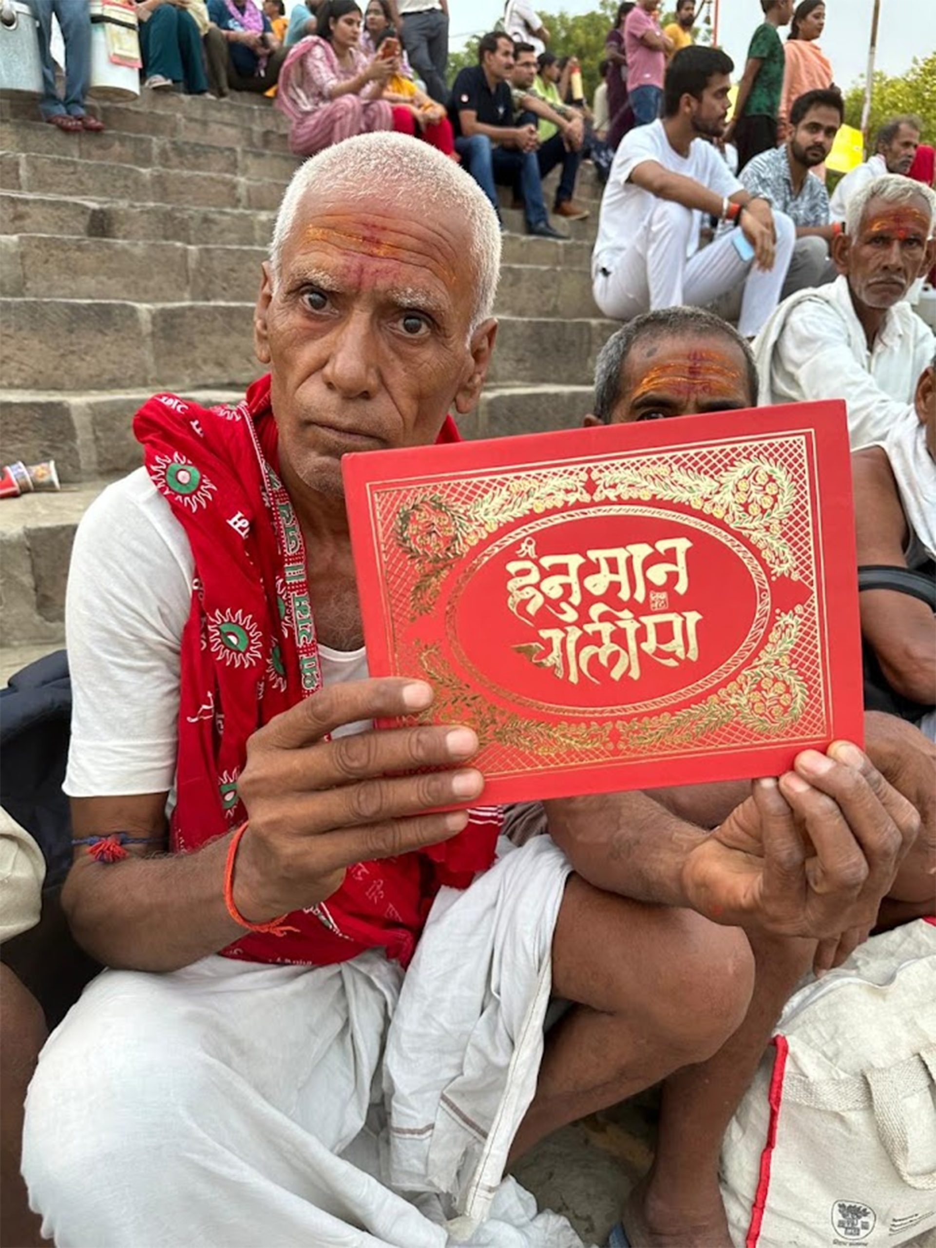 Devotee holding the Hanuman Chalisa Hand-calligraphed Hanuman Chalisa page with devotional artwork by Likhawat